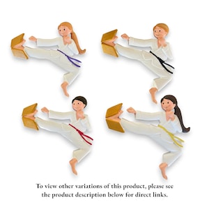 May include: Four ceramic figurines of people in karate poses, each breaking a wooden board with their foot. The figurines are wearing white karate uniforms with different colored belts. The belts are purple, black, red, and yellow.