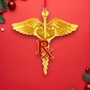 May include: Gold-colored Christmas ornament shaped like a medical symbol with a red "Rx" on the staff. The ornament has wings and a snake wrapped around the staff.