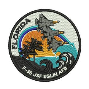 May include: A black and white embroidered patch with a sunset and waves. The patch features two F-35 fighter jets flying over the sunset. The text "FLORIDA F-35 JSF EGLIN AFB" is written on the bottom of the patch.