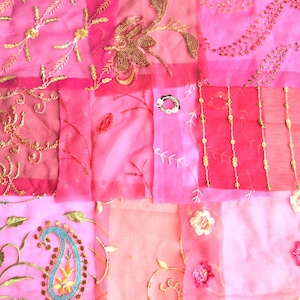 May include: A patchwork of pink fabric with gold and silver embroidery. The fabric is sheer and has a delicate, feminine feel.