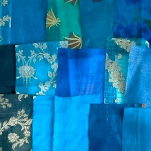 May include: Assortment of blue fabric swatches in various textures and patterns, including some with gold embroidery.