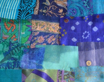 May include: A patchwork quilt made of various blue, green, and purple fabrics with floral and paisley patterns.