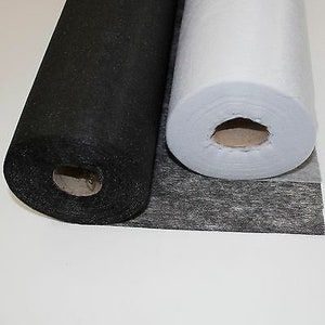 May include: Two rolls of fabric, one black and one white, are shown. The fabric is rolled up and the ends are visible. The fabric is likely for sewing or crafting.
