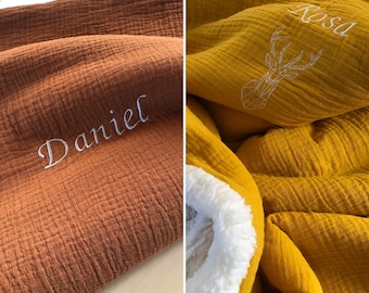 May include: Two personalized baby blankets, one brown with the name "Daniel" embroidered on it and one yellow with the name "Rosa" and a white embroidered deer design.