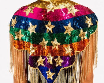 May include: A sequined capelet featuring horizontal stripes in red, gold, pink, blue, green, orange, and purple. The garment is adorned with numerous gold sequin stars and finished with long, dangling gold fringe along the scalloped hemline.