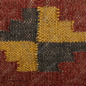 May include: Close-up of a woven fabric with a geometric pattern in shades of red, black, and gold.