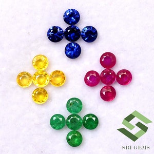 Może przedstawiać: Asortyment luźnych kamieni szlachetnych w różnych kolorach, w tym szafiry niebieskie, szafiry żółte, rubiny czerwone i szmaragdy zielone. Kamienie szlachetne są ułożone w symetryczny wzór na białym tle.  SBI Gems jest nadrukowane w prawym dolnym rogu.