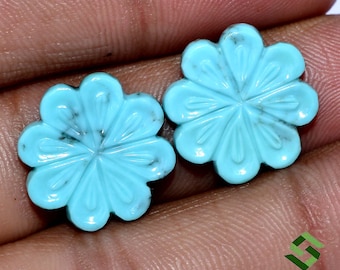 May include: Two turquoise blue flower-shaped cabochons with a carved design. The cabochons are approximately 1 inch in diameter.