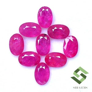 May include: Nine oval-shaped, pink ruby gemstones. The gemstones are faceted and have a high polish.