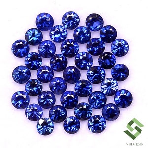 May include: A collection of 30 round, blue sapphire gemstones. The sapphires are faceted and have a bright, vibrant blue color.