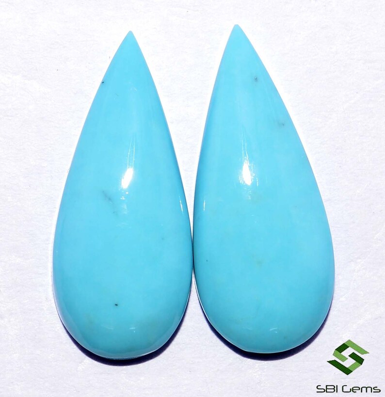 May include: Pair of teardrop-shaped turquoise cabochons, a light blue color with white veining.