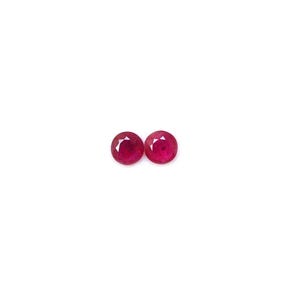 Puede incluir: Dos piedras preciosas redondas de rubí rojo.