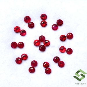 May include: A collection of twenty-one small, round, faceted red gemstones arranged in a circular pattern. Each stone features a brilliant cut with multiple reflective surfaces. The text SBI GEMS is printed in the bottom right corner.
