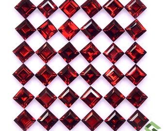 Può includere: Una collezione di gemme rosso scuro, tagliate a forma quadrata, disposte a griglia. Ogni gemma ha una superficie sfaccettata che riflette la luce. Le gemme sono su uno sfondo bianco, evidenziando il loro colore e la loro forma. La presentazione suggerisce la vendita di gioielli o gemme.