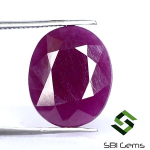 Puede incluir: Una piedra preciosa de rubí redonda y facetada con un tono rosa intenso. La piedra preciosa está tallada en un patrón geométrico único.