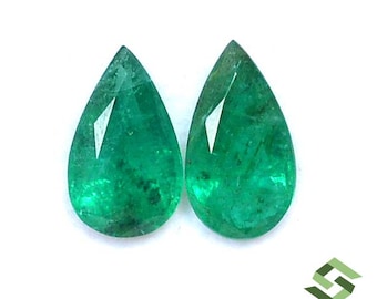 May include: Two pear-shaped emerald gemstones, each with a deep green color and a faceted cut.