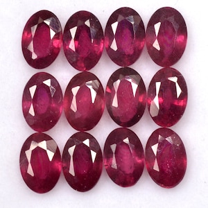 Puede incluir: Doce piedras preciosas de rubí de forma ovalada y facetadas. Los rubíes son de color rojo intenso y tienen un alto pulido.