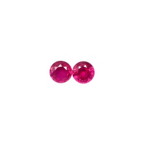 Puede incluir: Dos piedras preciosas redondas y rojas con un corte facetado.