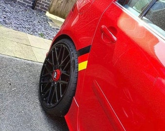 May include: A red car with black wheels and a German flag decal on the side.