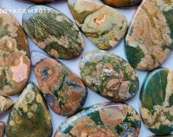 May include: A collection of polished gemstones in various shapes and sizes, featuring earthy tones of brown, green, and beige. The stones have unique patterns and textures, with a glossy finish. The text "zoyagems017" is visible.