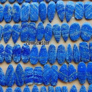 Puede incluir: Una colección de 50 cabujones de lapislázuli en forma de lágrima con inclusiones de pirita dorada. Las piedras son de un azul intenso con vetas blancas y miden de 2,5 a 5 cm.