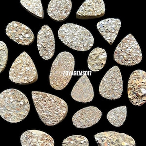 May include: A collection of 20 iridescent, gold-toned, natural agate slices. The slices are various shapes and sizes, with a rough, textured surface.
