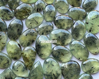 May include: A collection of 30 green aventurine cabochons with black inclusions. The cabochons are oval shaped and have a smooth, polished finish.  ZOYAGEMS017