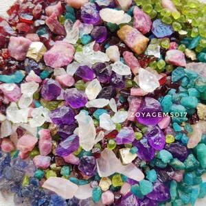 Può includere: Una collezione di pietre preziose colorate, tra cui ametista, rubino, smeraldo e zaffiro, in varie dimensioni e forme. Le pietre preziose sono disposte in un cerchio su uno sfondo bianco. Il testo "ZOYAGEMS017" è visibile al centro dell'immagine.