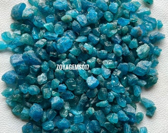 May include: A large pile of blue apatite rough stones. The stones are various sizes and shapes, with some having a more pointed shape. The stones are a vibrant blue color.