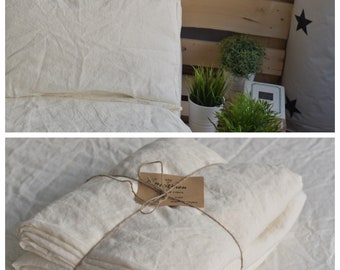 Puede incluir: Un juego de funda nórdica de lino blanco con una funda de almohada y una funda nórdica doblada. La funda nórdica está atada con una cuerda y una etiqueta que dice "100% Lino".