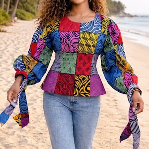 Peut inclure: Haut patchwork coloré à manches longues et taille péplum. Le haut présente divers motifs géométriques colorés en rouge, bleu, rose et jaune. Le modèle porte un jean bleu clair avec des genoux déchirés.