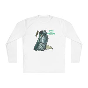 May include: White long-sleeve shirt featuring a detailed illustration of a fish with a person on its head. The text "Boca Grande Florida" is printed in green. The shirt is made of a soft, comfortable material.