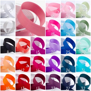 May include: A selection of ribbon spools in various solid colours. The ribbons include shades of pink, blue, and green, alongside neutral tones like beige and white. Each spool is labelled with a number.