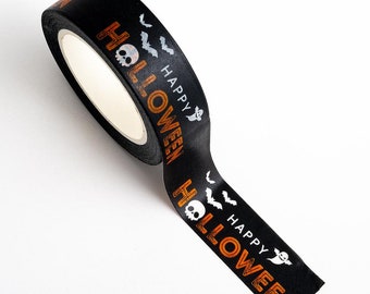 May include: A roll of black washi tape featuring a repeating pattern of orange text that reads HAPPY HALLOWEEN, white skulls, small white bats, and white ghosts. The tape has a matte finish and is shown partially unrolled on a white surface.