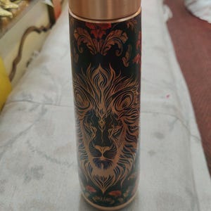 May include: A white ceramic mug with a black handle and the text "But First, Coffee" in a black, bold font. The mug is on a wooden surface. The mug is approximately 10 cm tall.