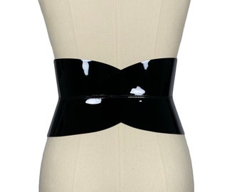 May include: A black patent leather belt with a curved, hourglass shape.