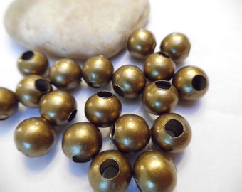 May include: A group of 18 gold wooden beads with a hole in the center. The beads are round and have a smooth, shiny finish.