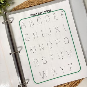 May include: A clear binder with a worksheet that says "Trace the Letters" at the top. The worksheet has the alphabet in dotted lines for tracing. The worksheet is inside a clear plastic sleeve.