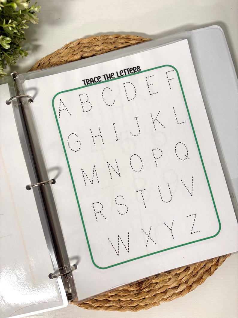 May include: A clear binder with a worksheet that says "Trace the Letters" at the top. The worksheet has the alphabet in dotted lines for tracing. The worksheet is inside a clear plastic sleeve.