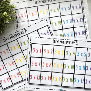 May include: Educational multiplication charts with colorful equations, including "Let's Multiply by 2!", "Let's Multiply by 3!", and "Let's Multiply by 4!". The charts feature multiplication problems in a grid format, designed for learning.