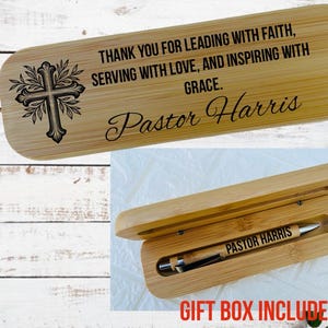 May include: A bamboo pen and case set. The case lid is engraved with a cross design and the words "THANK YOU FOR LEADING WITH FAITH, SERVING WITH LOVE, AND INSPIRING WITH GRACE. Pastor Harris." The pen is engraved with "PASTOR HARRIS."
