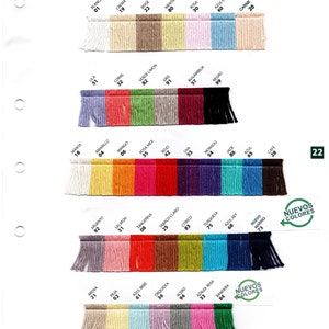 May include: A color chart for Omega Eulal&iacute; yarn, featuring a variety of hues. The chart displays swatches of yarn in shades like white, beige, pink, blue, and green. Each swatch is labeled with a color name and number. The text "Nuevos Colores" is also visible.