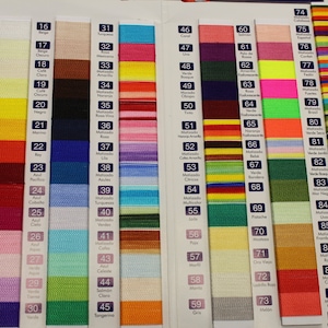May include: A color chart with 89 different thread colors. The chart is divided into columns with numbers and Spanish words. The colors are arranged in a rainbow pattern.