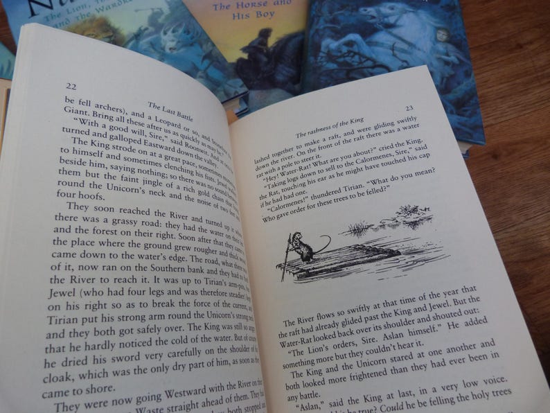 May include: A close-up of a page from a book titled "The Last Battle" with text about a unicorn and a river. The text reads, "They soon reached the River and turned up a grassy road: they had the water on their right. Soon after that they came down to the water's edge. The road, when it, now ran on the Southern bank and there was the River to reach it. It was up to Tirian's arm's length and was therefore carried on his right so as to break the force of the current. Tirian put his strong arm round the Unicorn's neck and they both got safely over. The King was so strong that he hardly noticed the cold of the water. But as soon as he dried his sword very carefully on the shoulder of his cloak, which was the only dry part of him, as soon as they came to shore."