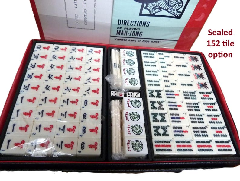 Peut inclure: Un jeu de Mah-Jong dans un coffret rouge et noir, comprenant des tuiles blanches avec des caract&egrave;res, symboles et marquages Joker en rouge, bleu et vert. Le set inclut un manuel intitul&eacute; Directions of Playing Mah-Jong et une option 152 tuiles.