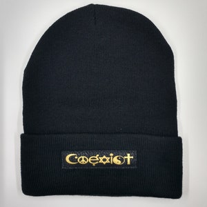 May include: Black beanie with a black leather patch that says "Coexist" in gold lettering with symbols for peace, a Star of David, a crescent moon, and a yin-yang.