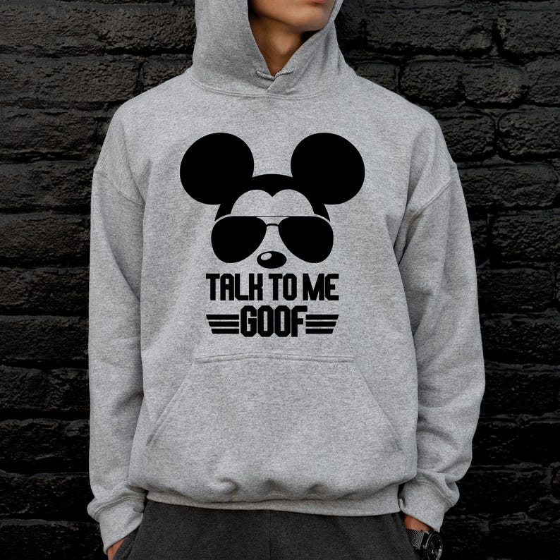 May include: A heather gray hooded sweatshirt featuring a black graphic of a mouse silhouette wearing sunglasses. Below the graphic, the text reads TALK TO ME GOOF in a bold, black sans-serif font, accented by horizontal lines above and below.