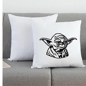 May include: Two square white throw pillows. One pillow is plain white, while the other features a bold, black graphic illustration of the character Yoda, showing the head and shoulders with pointed ears and facial wrinkles in a stylized design.