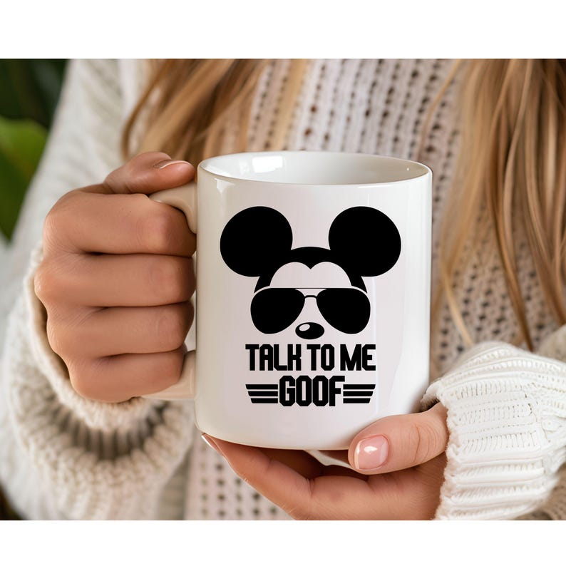 May include: A white ceramic mug featuring a black graphic of a mouse silhouette wearing sunglasses. Below the graphic, the text reads TALK TO ME GOOF in bold black capital letters, flanked by two horizontal lines on each side of the word GOOF.