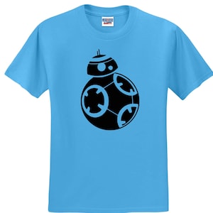 May include: A bright light blue short-sleeved t-shirt featuring a centered black graphic print of the BB-8 droid. The shirt has a crew neckline and a standard fit, with a small white brand label visible on the inside of the collar at the neck.